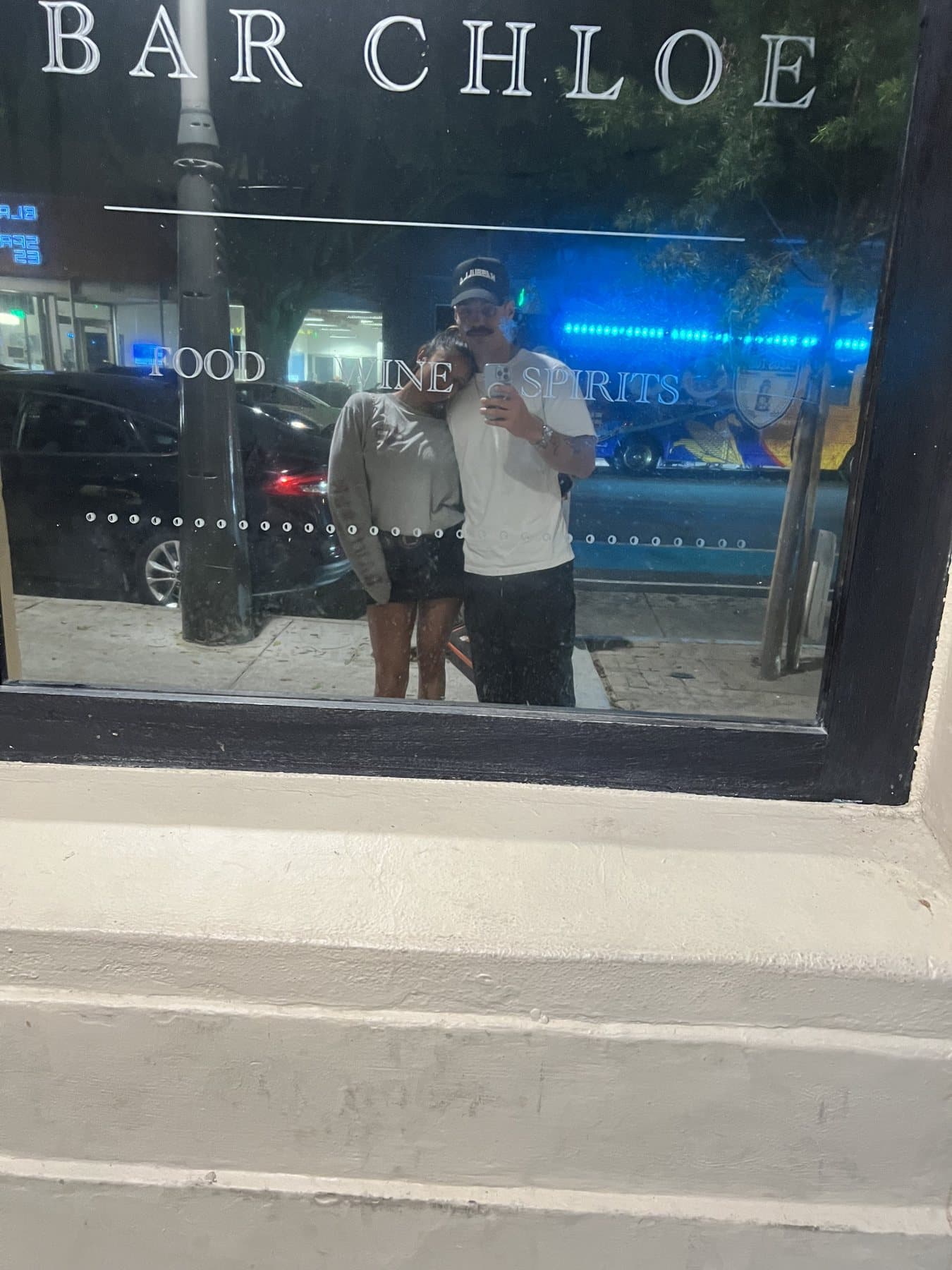 Anishka and Jack reflected in the window at Bar Chloe on their first date